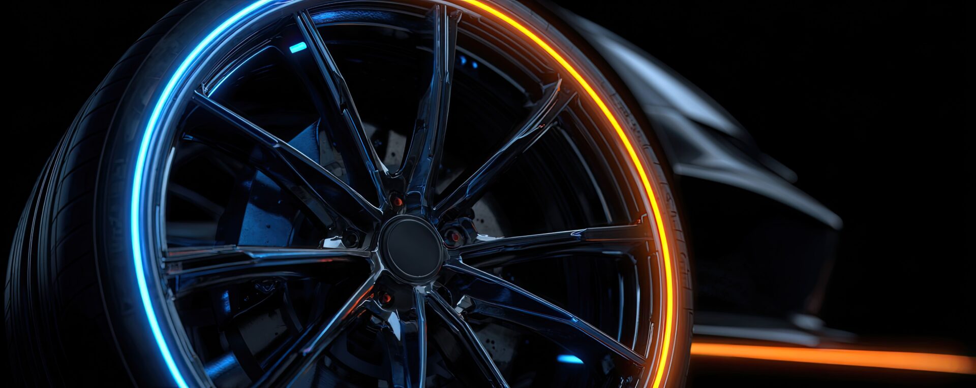 Il dettaglio del cerchio in lega di un'automobile illuminato con luce arancione/dorata.
